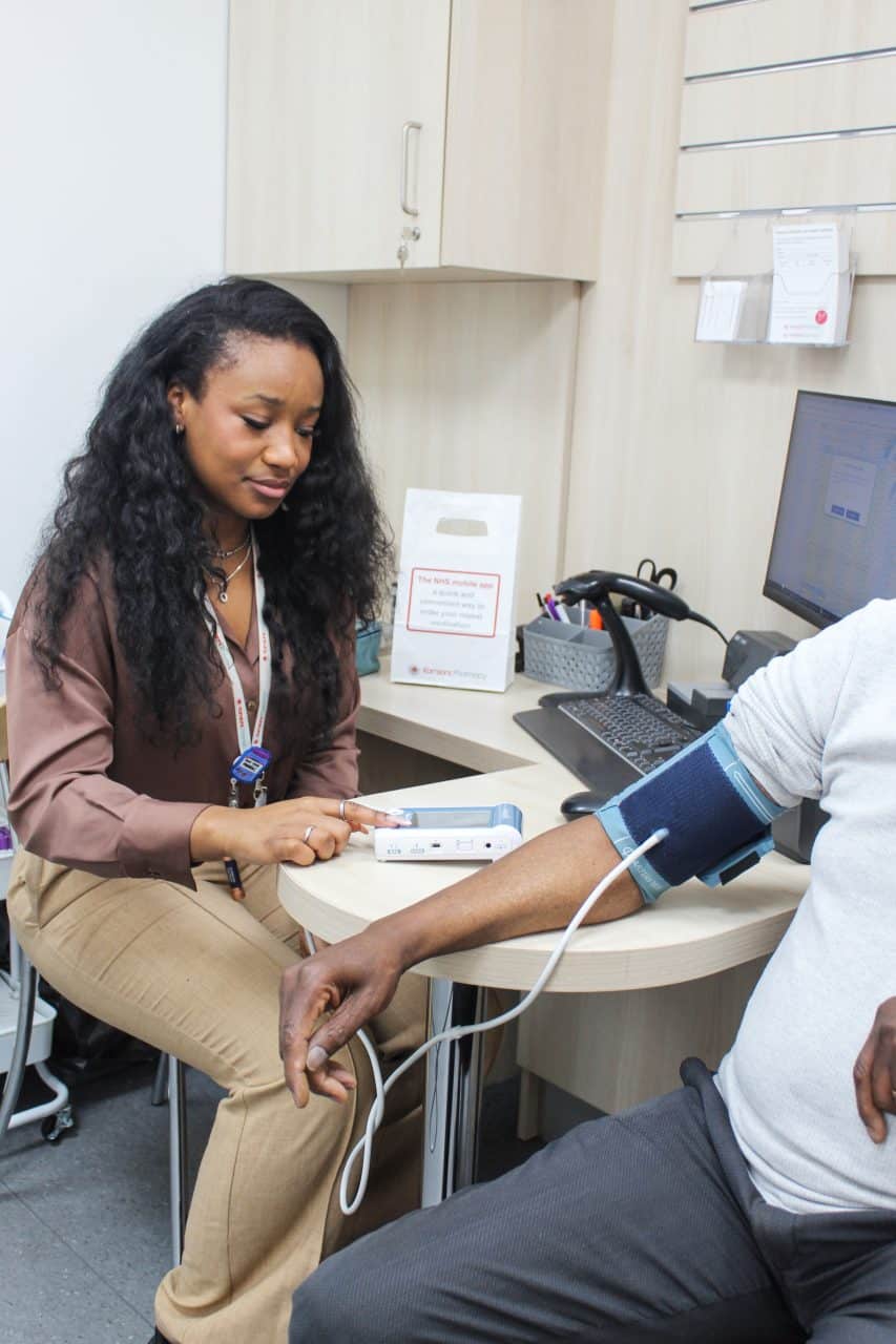Image of a Kamsons Pharmacist checking someone's blood pressure