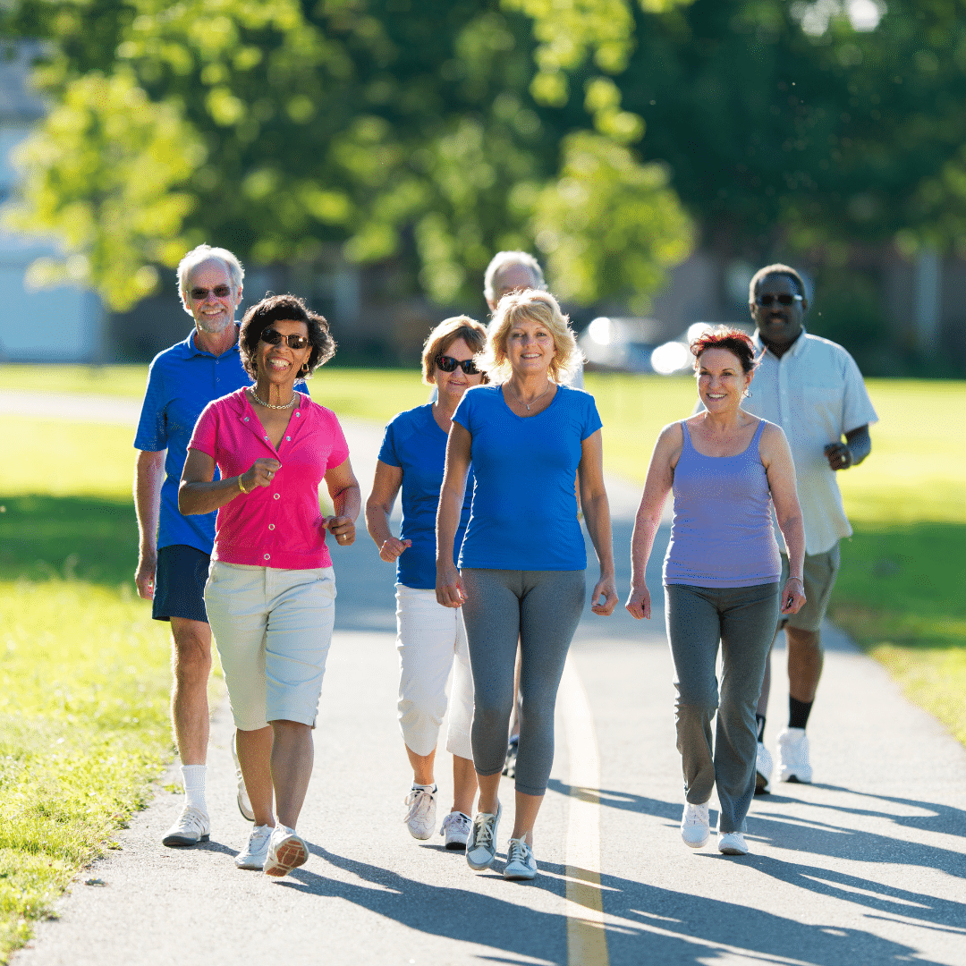 image of a group of 7 people walking outside in the sun to improve health and wellbeing